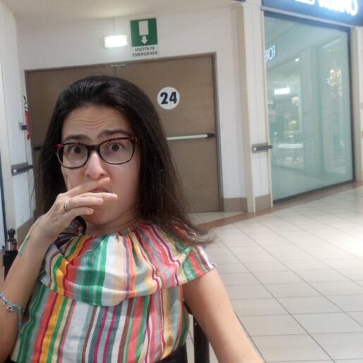 Maria Chiara in un centro commerciale seduta sulla sua sedia con una mano sulla bocca