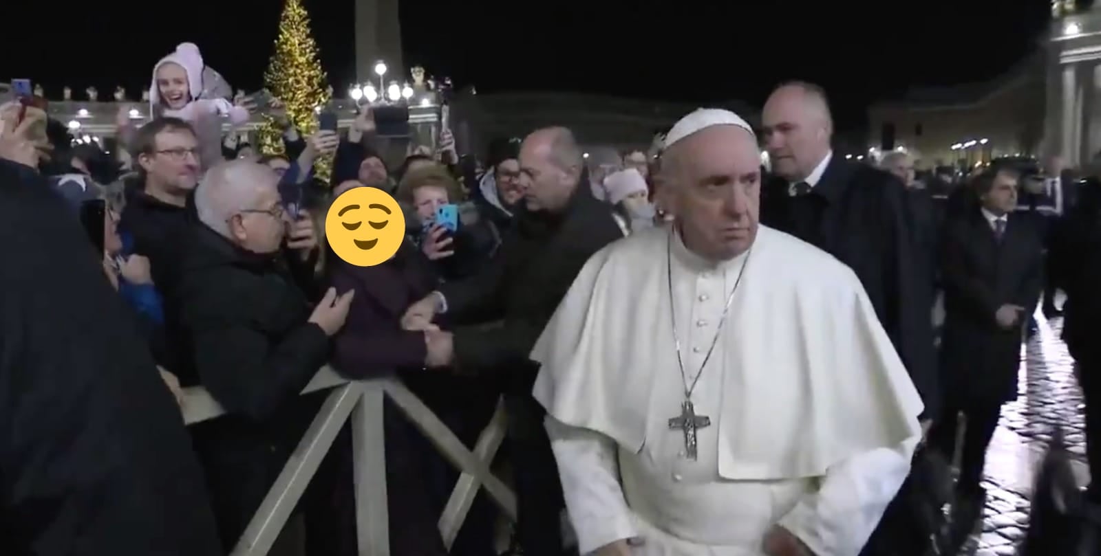 Papa Francesco si allontana con aria scocciata da una signora che lo strattonava (il cui volto è coperto da un'emoji)