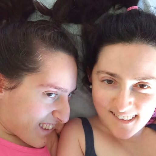 un selfie di Elena e Maria Chiara distese con le teste vicine. Elena indossa una canottiera rosa acceso e Chiara una canottiera blu scuro. Entrambe hanno i capelli raccolti in delle code e sorridono.